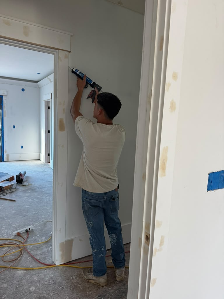 Caulking a door casing before paint.