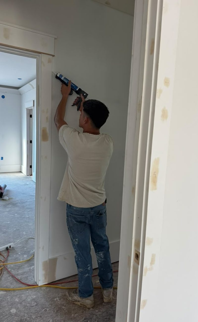 Caulking a door casing before paint.